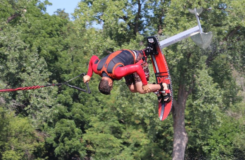 A water skier flies through the air. A human pyramid of water skiers. Courtesy Ski Extreme Productions.